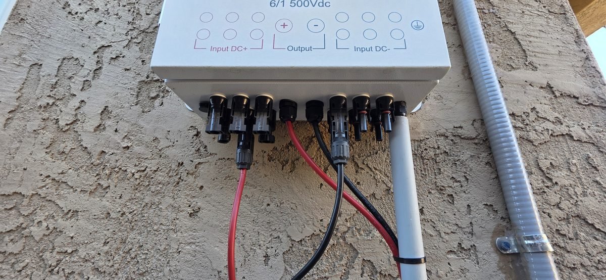 MC4 connectors on the bottom of a PV combiner box with Input DC+, Output, and Input DC- ports
